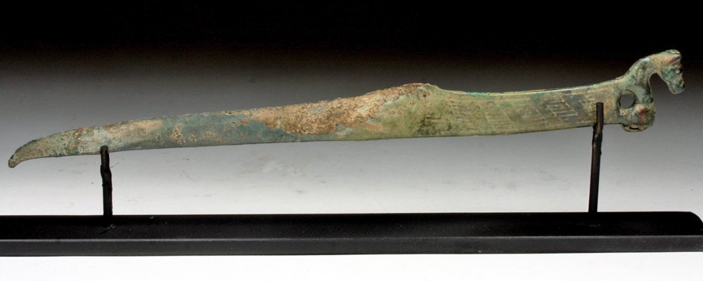 Chinese Ordos Bronze Knife - Horse Handle: Northern China, Late 2nd Millennium BCE, Shang Dynasty to Western Zhou Period. A very fine bronze knife of typical Ordos curved form, decorated on handle with deeply incised decoration, a horse lookin