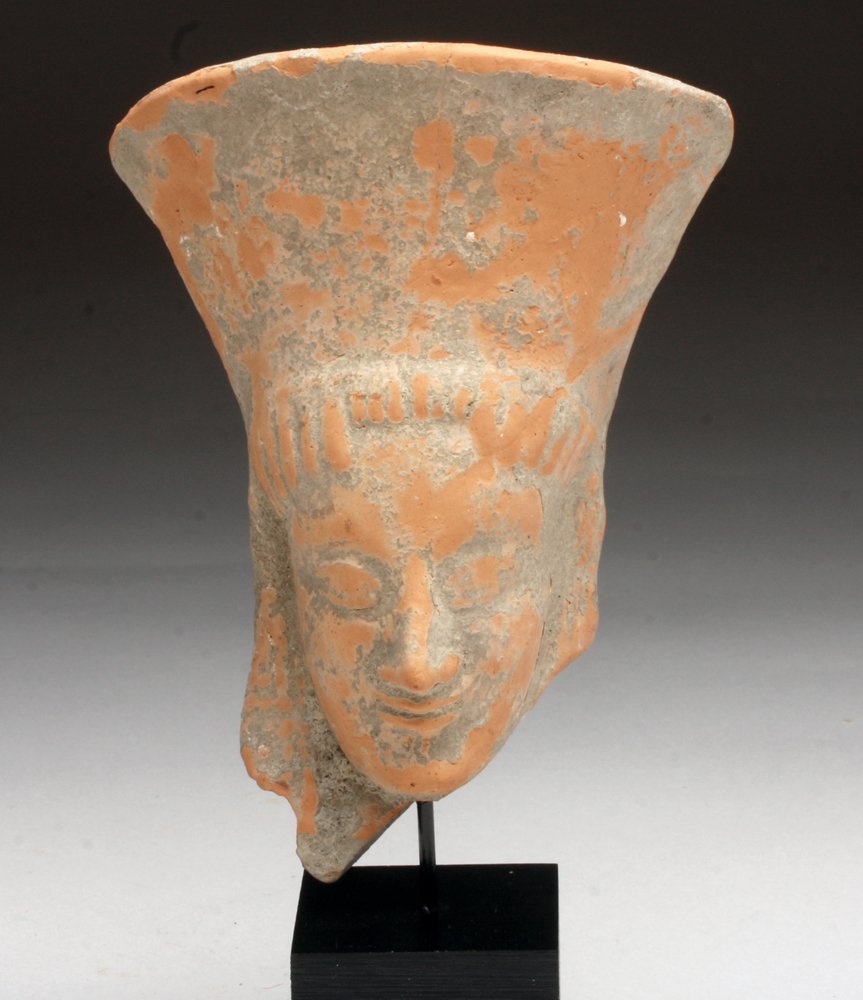 Large Archaic Greek Redware Protome: Western Greece, 6th century BCE. An Archaic Greek Terracotta Protome Goddess, Western Greek, probably Sicily, ca. 500 B.C. Woman's head with slender face, long hair, polos and disc earrings. Her lips