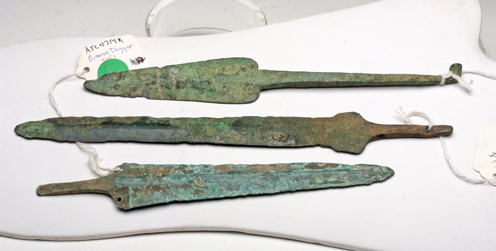 Lot of 3 Luristan Bronze Spear Blades: Northwestern Iran, Ca 1000 to 800 BCE. Set of three bronze spear tips, each short tang, one perfed and one with hooked tang for suspension into wooden shaft. 10" L for longest. Provenance: Ex-Connell 