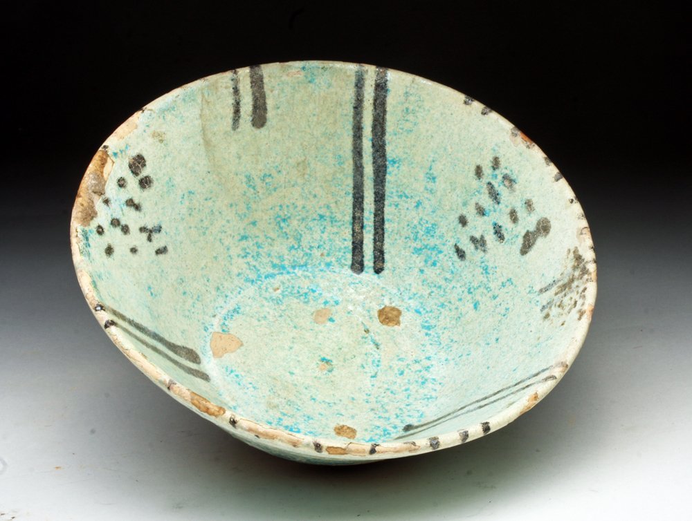 Islamic Blue Glazed Deep Bowl: Turkey/Iran, Ca 12th to 14th century. Beautiful deep bowl on short foot decorated on the interior with deep blue glaze highlighted with added black, all developing a silvery blue/green iridescent surf
