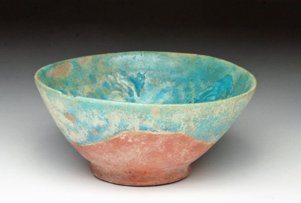 Islamic Blue Glazed Bowl, possibly Kashan: Iran, Ca 12th to 14th century, possibly Kashan region. A stunning sky blue ceramic bowl impressed in the center with floral patterns. Areas of silvery iridescence! 4-3/4" D. Provenance: Ex-Smith colle