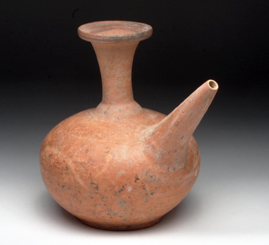 Fine Cambodian Khmer Kendi: Cambodia, Khmer period, Ca 12th century CE. A fine Cambodian terracotta Kendi (teapot). An elegant form with rounded body, tapering neck and flared top. A cone-shaped spout on the side for pouring. Th