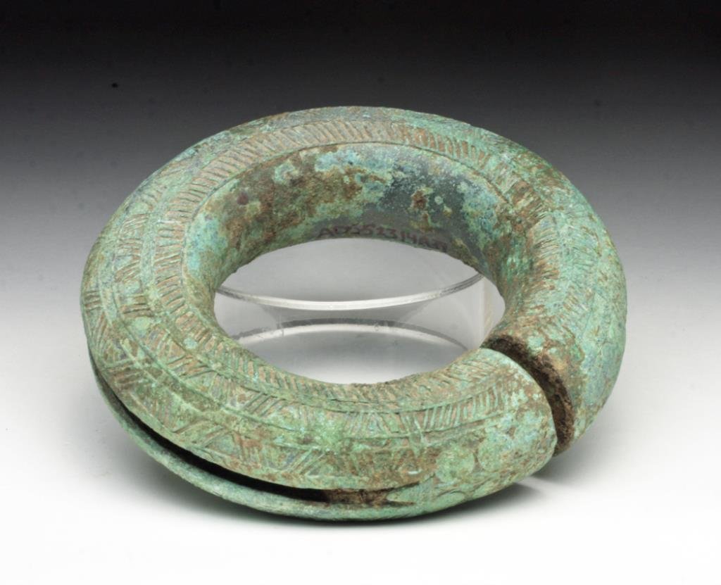 Huge Dong Son Bronze Bracelet: Viet Nam or Cambodia, Ca 1st millennium BCE. Large and wonderfully decorated bronze bracelet or anklet, with hollow interior to encase a small stone so it jangles when shaken or when walking. Certainl