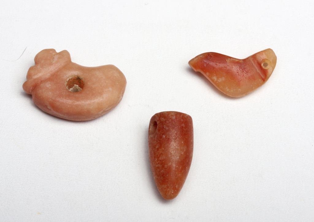 Lot of 3 Tairona Carnelian Amulets: Pre-Columbian, Colombia, Tairona culture, Ca 500 to 1500 CE. Nice set of three carnelian agate beads from this culture known for their exquisite carnelian beads! Set includes a rather abstract jaguar 