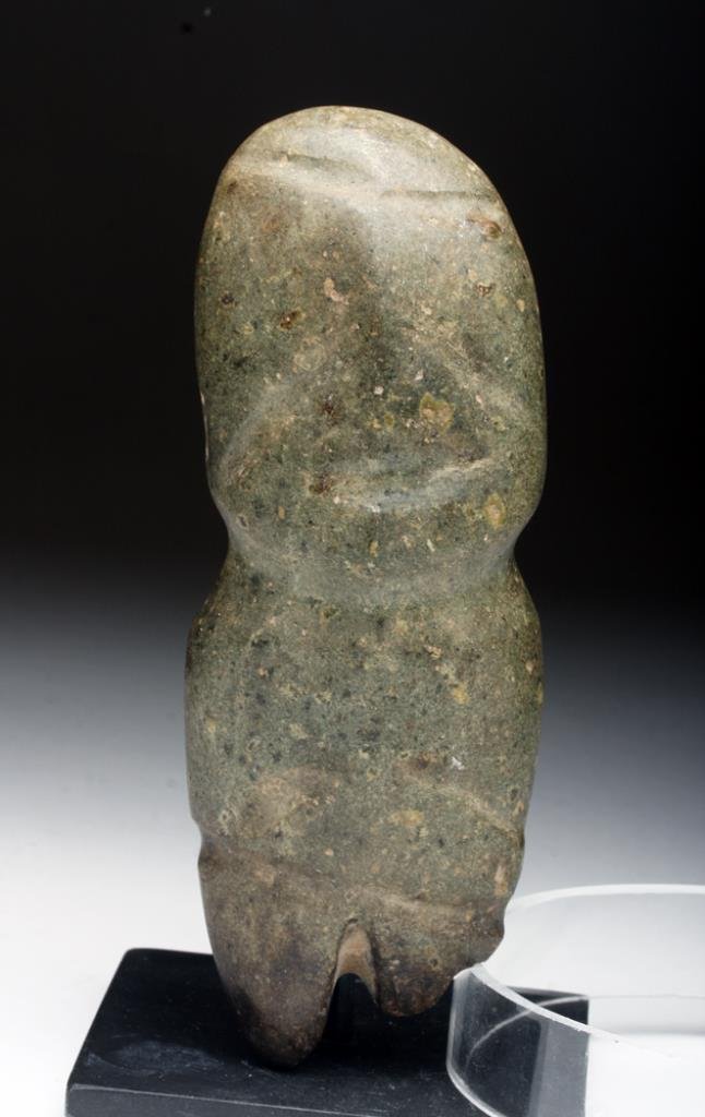 Guerrero Mezcala Stone Standing Figure: Pre-Columbian, Guerrero, Mexico, Ca 400 to 200 BCE. A stone carving of a standing human. Medium to dark green stone standing figure with large head hands held to chest and typical string cut features.