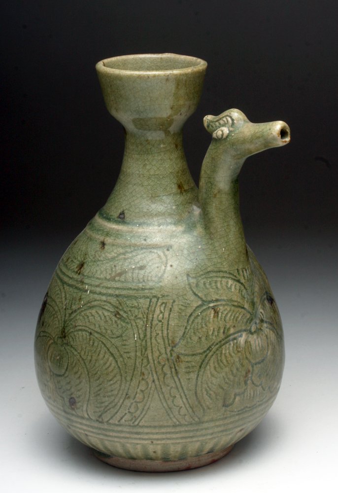 Gorgeous Anamese Green Glazed Pouring Jar: Southeast Asia, Ca 13th to 14th centuries. A truly fabulous pottery pouring vessel, with bulbous base and thinning neck and small rim, with dragon-headed spout, all covered in a celadon green glaze an