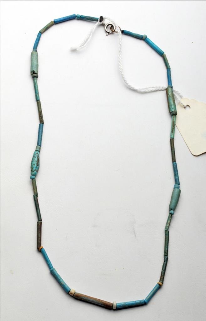 Egyptian Faience Necklace: Egypt, Third Intermediate Period, Ca 1030 to 715 BCE. Necklace comprised of multiple faience beads in shades ranging from light blue to green/brown. Four of the beads are a more unusual heavy thick be