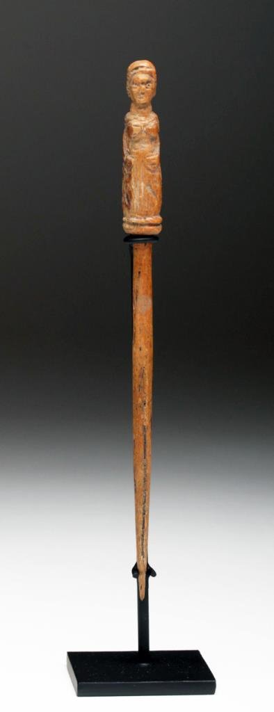Ancient Roman Bone Hairpin: Roman Empire, Ca 2nd century CE. Lovely hairpin, carved on the top with an image of a female goddess, probably Fortuna or Minerva, wearing draped chiton, hands to her sides. Reportedly found in Britai