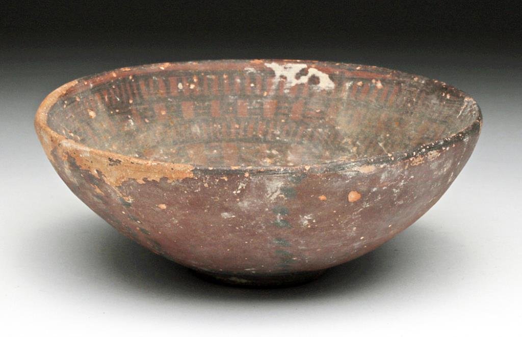 Indus Valley Decorated Redware Bowl: Pakistan / Baluchistan, Ca 3000 BCE. Large and rare deep pottery bowl. Redware, an earlier variety of vessel from this region, on short foot, decorated on the interior with geometric pattern in black.