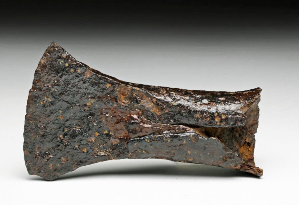 Celtic Iron Axe - Beautiful Patina: Central Europe, Ca 100 to 300 CE. Fine slotted iron axe head, almost petrified wooden handle in the sleeve. 4-1/2" L. Provenance: Ex-J. Connell Collection. All items legal to buy/sell under U.S. Statu