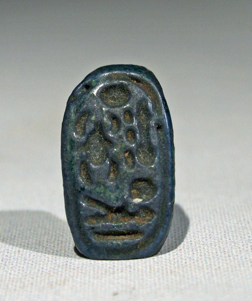 Egyptian Faience Ring Plaque - Amenhotep IV: Egypt. Reign of Amenhotep IV, Ca 1300 BCE. Oval faience plaque from a faience ring. Plaque is inscribed with the throne name of Amenhotep IV, "Nefer-kheperw-ra wa-en-ra" translated as "Perfect are the