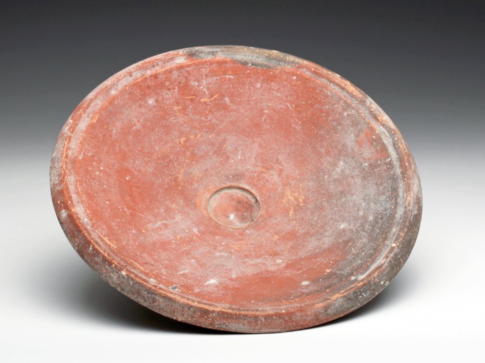 Hellenistic Footed Plate found in Sinai, ex-Barakat: Israel, found in Sanai, Ca 300 to 100 BCE. Choice pottery redware vessel of the type most often associated with Greek fish plates. Small central depression, short foot and raised rim. 7-5/8" D. Proven