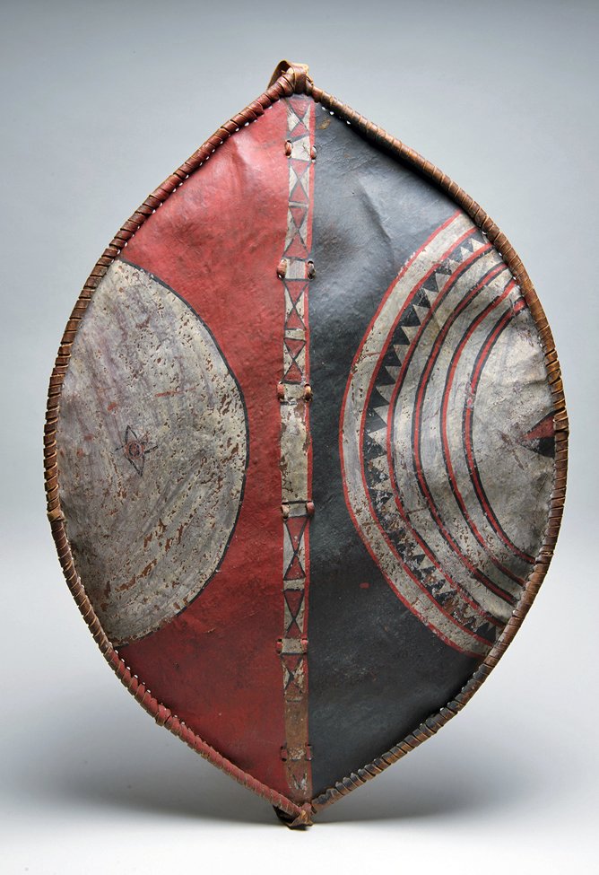 Masai Painted War / Heraldic Shield: Masai people, Kenya or Tanzania, mid-20th century CE. Of convex elliptical form, made from dried and tanned animal skin and decorated with handmade paints made from berries. Used mainly for hunting, w