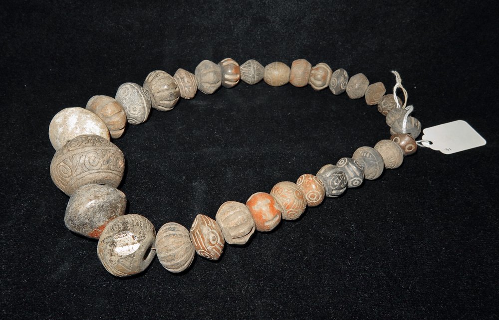 31 Pre-Columbian Beads and Whorls Necklace: West Mexico, Nayarit or Colima, Ca 200 BCE to 200 CE. Large strand of mostly decorated beads and whorls. 21" long pottery geometric, painted, plain, and melon types. Provenance: Ex-Lynn Langdon collec