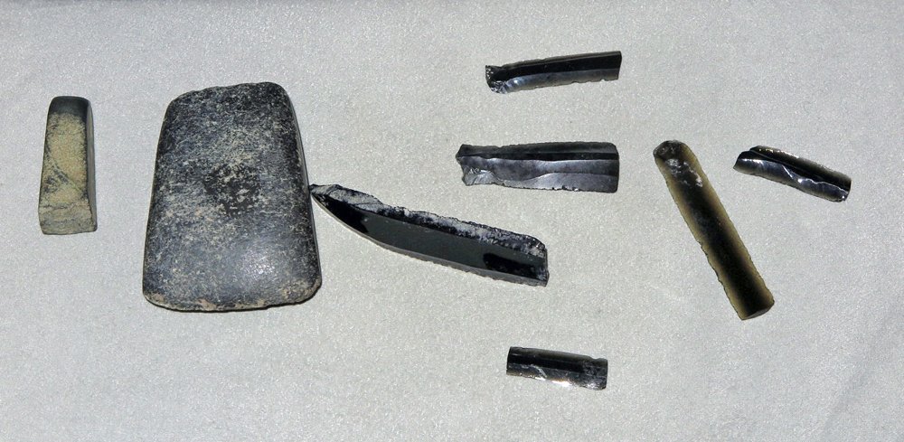 Lot of 8 Assorted Pre-Columbian Stone Tools: Nayarit Region, W. Mexico, CA.1000 BCE to 1300 CE. The 2-7/8" long trapezoidal celt was made from volcanic basalt. The 5 cm long chisel is a greenstone. The opaque to translucent 3 to 8 cm long flake 