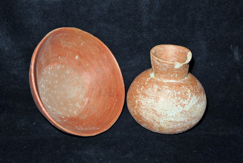 Lot of 2 Pre-Columbian Grater Bowl + Jar: Colima, West Mexico, Ca 300 BCE to 300 CE. The fairly large grater bowl with a ringed base measures 8-5/8" in width while the orange jar is 4-1/2" tall. Provenance: Ex-Lynn Langdon collection acquired