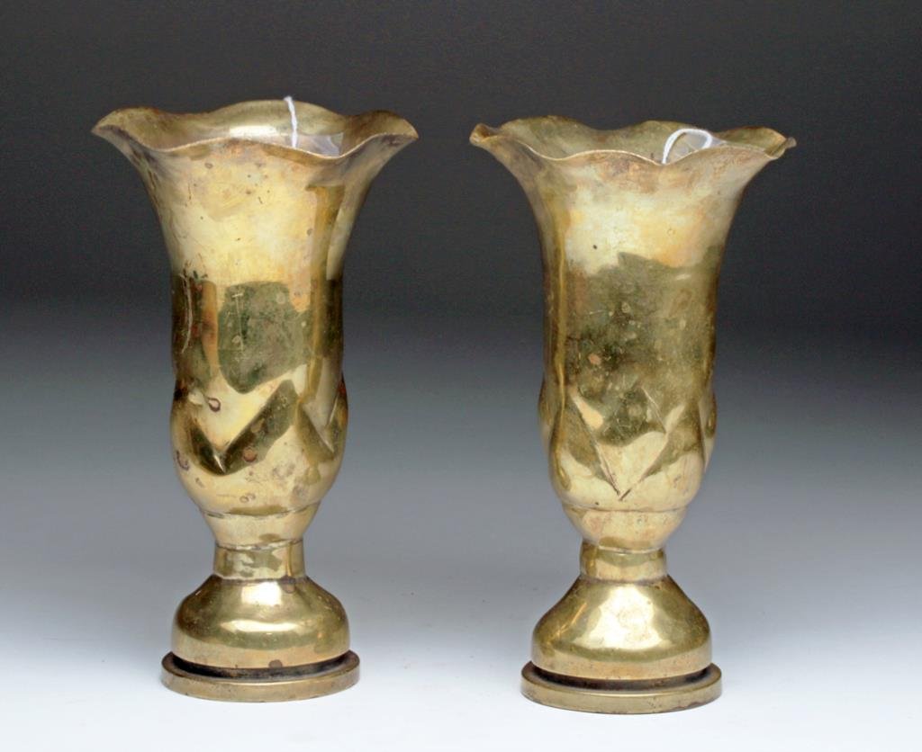 Lot of 2 WWI / WWII Brass 50mm Shell Trench Art Vases: US, Ca 1917 to 1945, unsure whether Pacific or European Theater. A pair of decorated 50mm shells, pinched at base and tops turned into floral petals. Each 6-3/4" H. A lovely reminder of a brutal perio