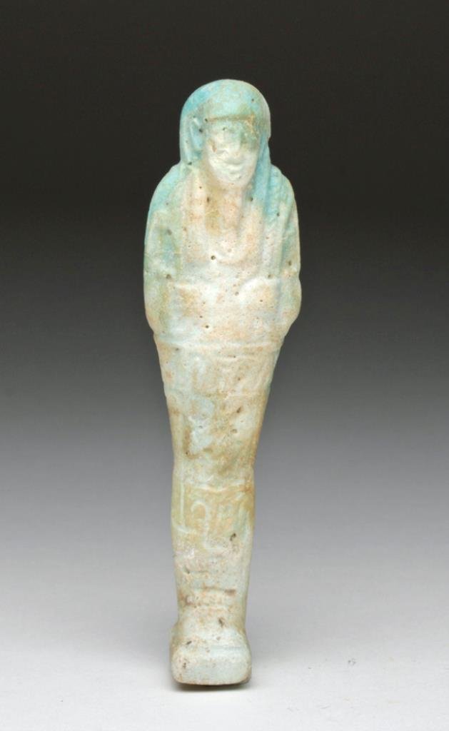 Egyptian Faience Ushabti - Hieroglyphs: Egypt, Late Dynastic Period, Ca 662 to 330 BCE. Light blue faience ushabti that has oxidized to very pale blue to nearly white, with six lines of glyphs down the front panel, servant holding crook and