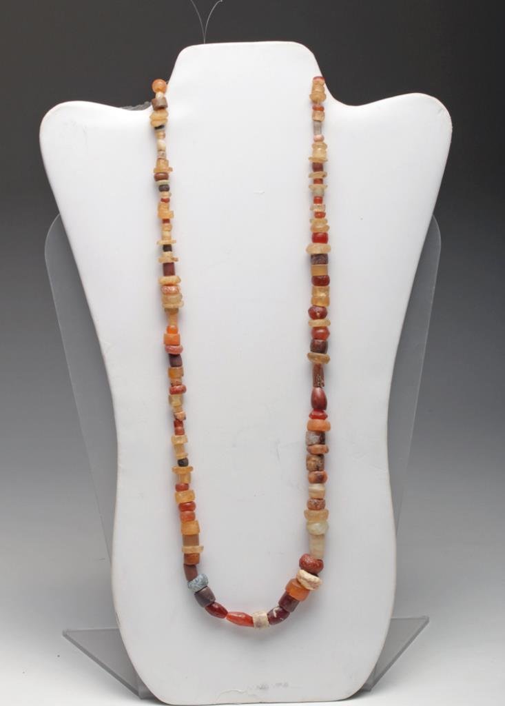 Bactrian Necklace of Colorful Stones: Bactrian culture, Pakistan, Afghanistan, Ca 1st millennium BCE. Another very beautiful necklace comprised of carnelian beads, most polished into ovoid form, one modern bead at terminal. 25" L. Provena