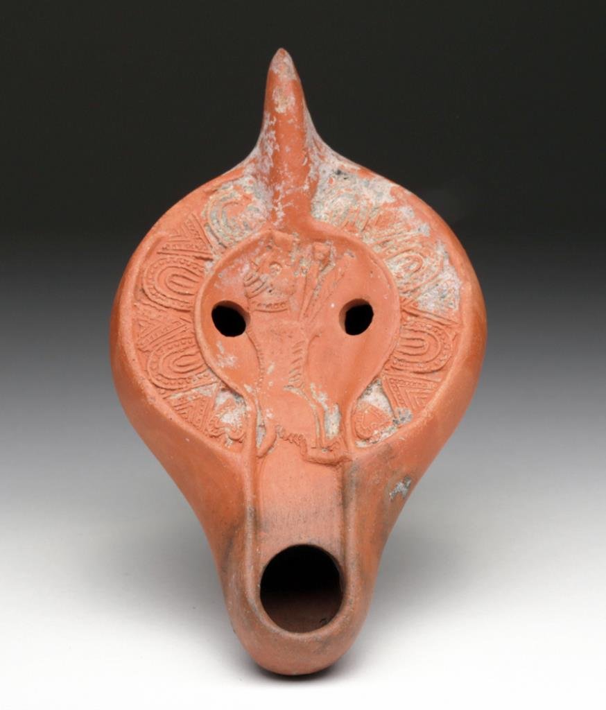 Roman Oil Lamp -Wild Boar: Roman, Tunisia, ca. 4th to 5th century CE. Ancient Roman redware pottery oil lamp, found in Tunisia. Mold made with large opening at spout and two vent holes, central discus adorned with a finely deli