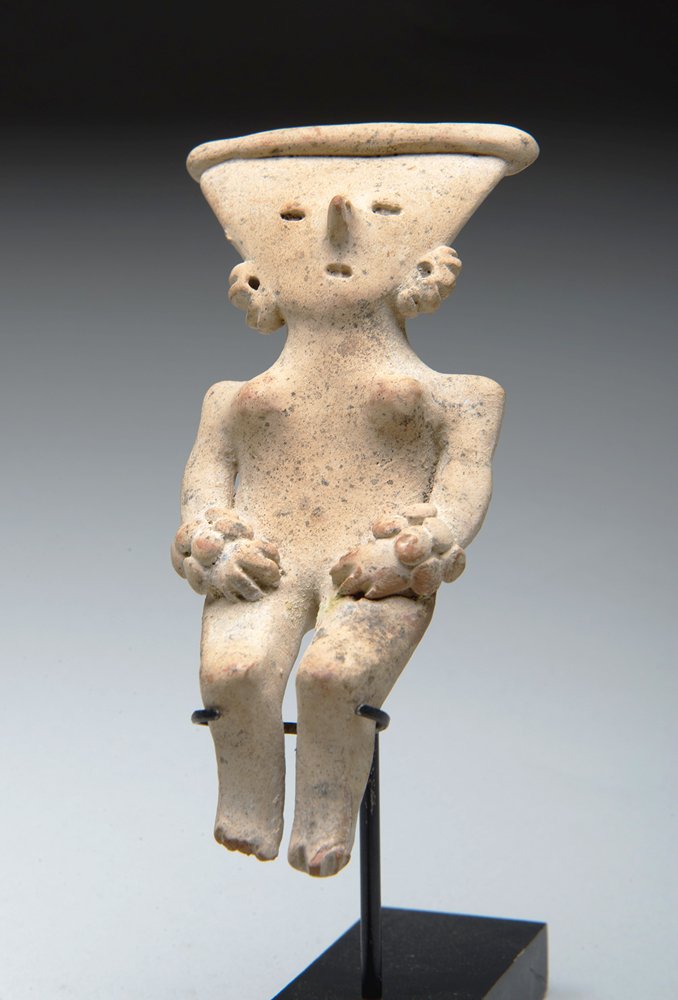 Michoacan Pretty Lady Seated Flat Figure: Pre-Columbian, West Coast Mexico, Ca. 500-100 BCE. Solid terracotta pretty lady type female figure wearing ear and hand ornaments with rectangular band headdress. Figure itself measures 5"H x 2-1/4"W.