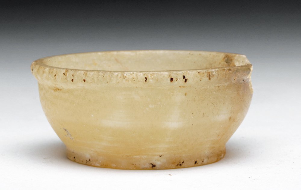 Egyptian Offering Cup - Translucent Alabaster: Egypt, Middle to New Kingdom, Ca 2000 to 1000 BCE. Attractive smaller cup in creamy translucent banded alabaster with short foot and serrated edge. 2"D x 7/8" H. Provenance: Ex-Ann Attal collection a