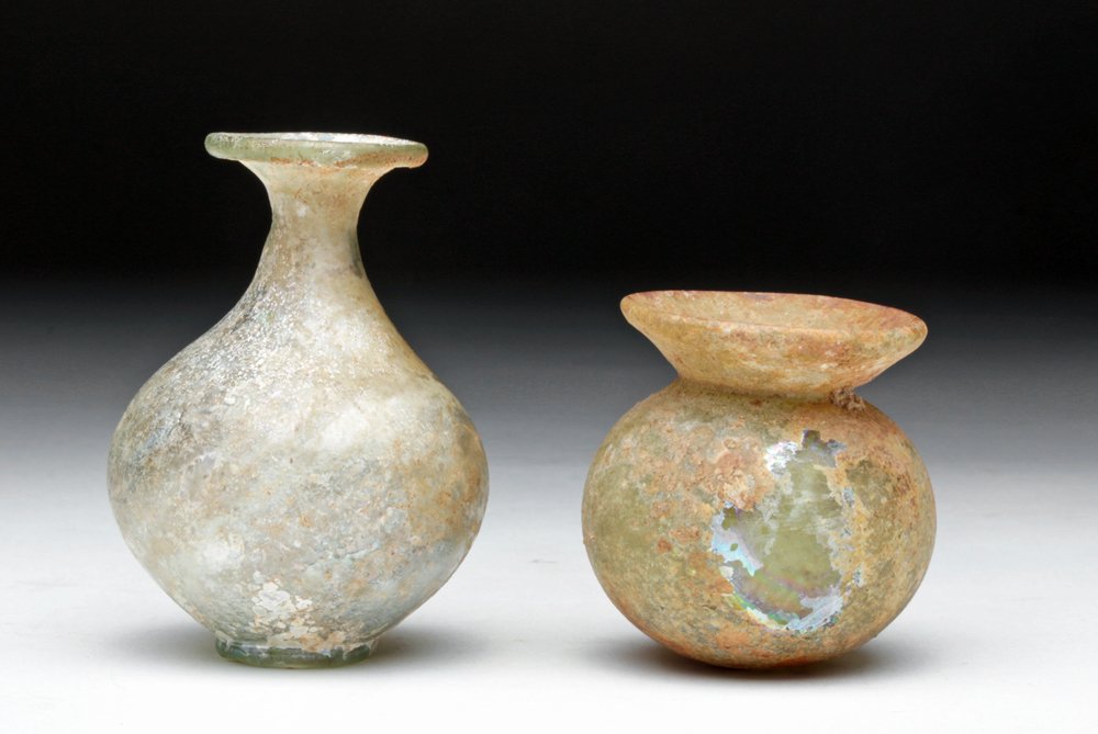 Fine Pair of Roman Glass Jars: Roman Empire, Ca 2nd to 4th centuries CE. Pair of very delicate Roman glass jars. First is squat example in very rounded form with flaring rim. Surface deposits can be easily removed to reveal gorgeou