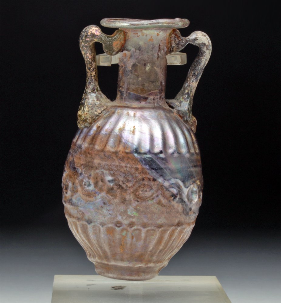 Roman Sidonian Molded Glass Amphora: Roman , Sidonian, Lebanon, ca. 1st century CE. A fine mold-blown miniature amphora in gorgeous Aubergine hued glass. Note how the mold was carefully crafted to delineate intricate detailing. Sidon was