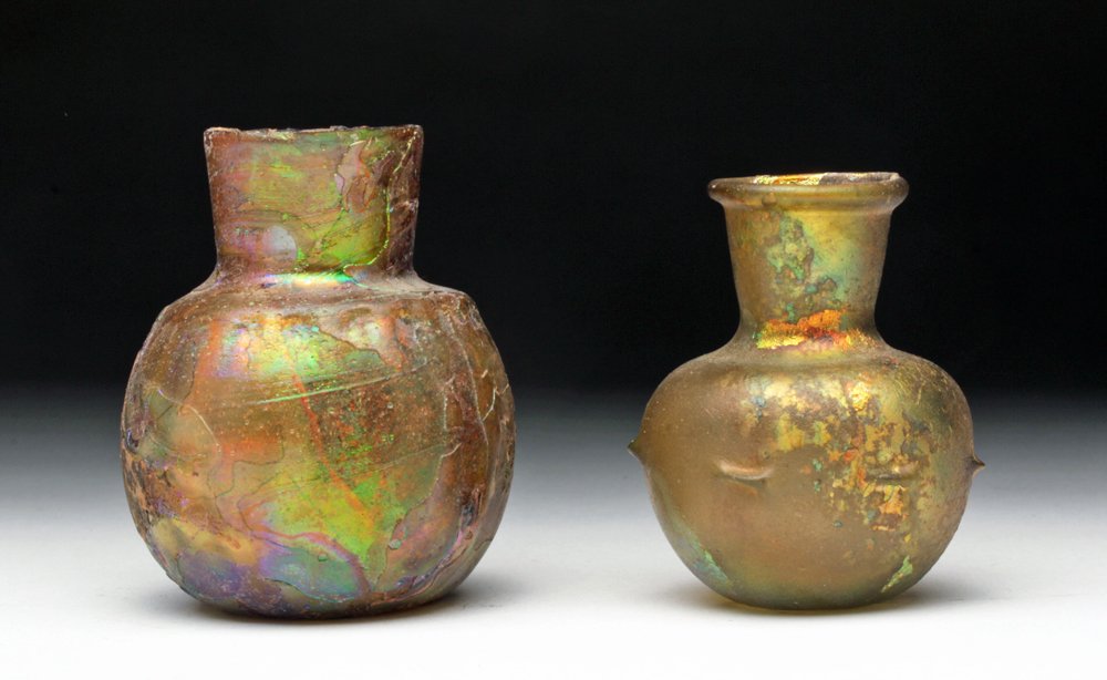Exceptional Pr. Roman Glass Vessels - Fiery: Roman, the Levant (Israel, Lebanon, Syria), ca. 3rd century CE. Two Roman glass beauties! First a simple vessel with dimpled bottom, spherical body, short neck, and abundant golden, rainbow iridescenc