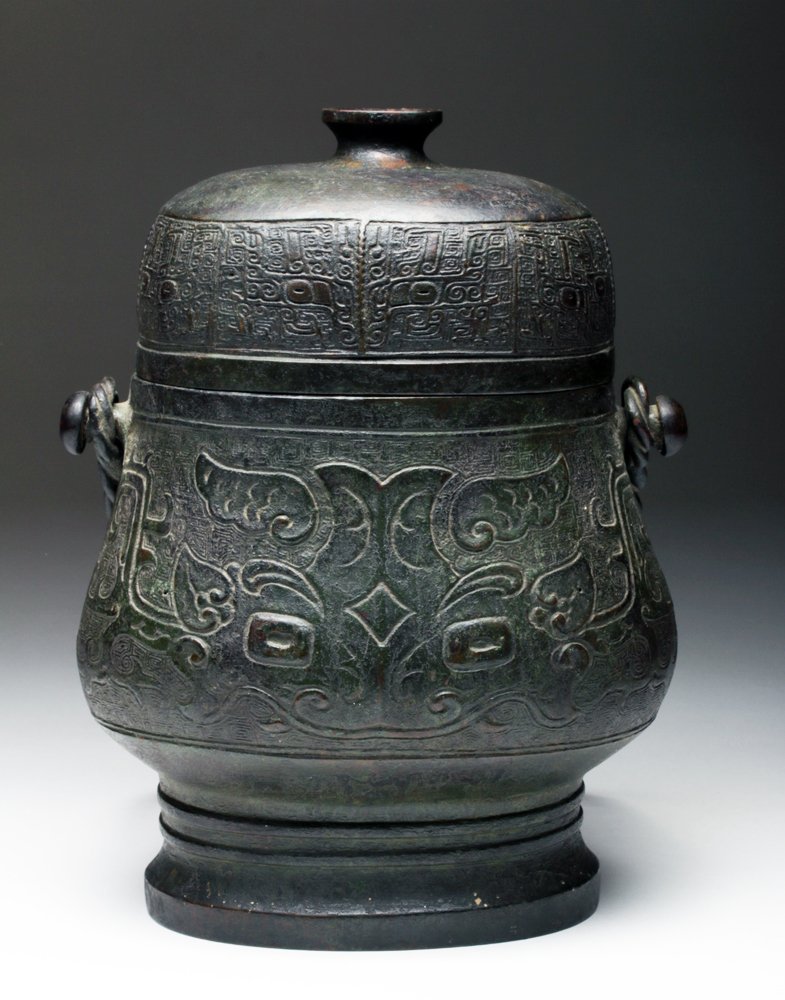 Stunning Ming Dynasty Bronze Covered Yu (You): China, Ming Dynasty (or possibly earlier), ca 1368 to 1644 CE. Bronze covered ceremonial vessel used to hold wine. Oblong shaped vessel with raised and incised decorations on each side. To the front a