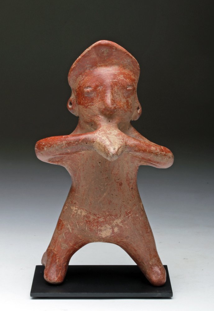 Colima Pihuamo Pottery Musician: Pre-Columbian, Western Mexico, Colima, Pihuamo Style, Ca 200 BCE/CE. Finely modeled pottery standing male musician. He stands with legs wide apart, both hands held to conch shell that he blows as a tr