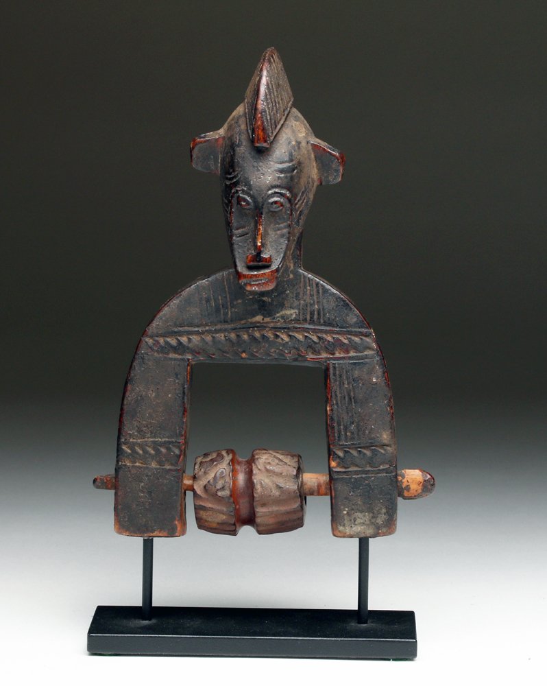 Senufo Carved Wood Heddle Pulley: Africa, Ivory Coast, Côte d'Ivoire. Lovely carving with stylized human head with a central crest atop head and elongated face. A well-carved example in classic style showing usage and bobbin intact. 