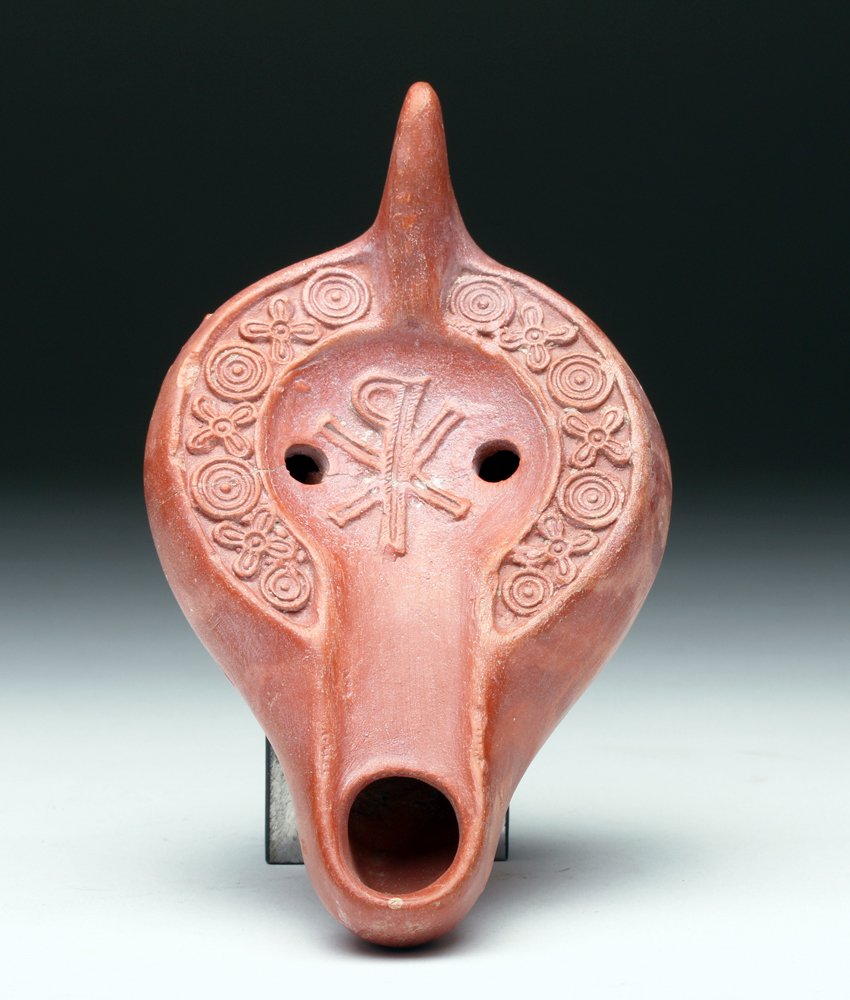 Roman Chi Rho Redware Oil Lamp: Roman Empire, Carthage, North Africa, 4th to 5th century CE. As the Christian religion began to take hold and spread throughout the Roman Empire, lamps such as these became more common and politically