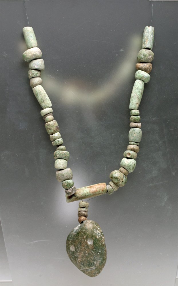 Mezcala Stone Bead Necklace - Face Pendant: Pre-Columbian, Guerrero, Mexico, Mezcala, ca. 200 BCE - 200 CE. Mezcala necklace comprised of pale green stone beads with elegant mottled patterns of serpentinite grading, carved into cylindrical, loz
