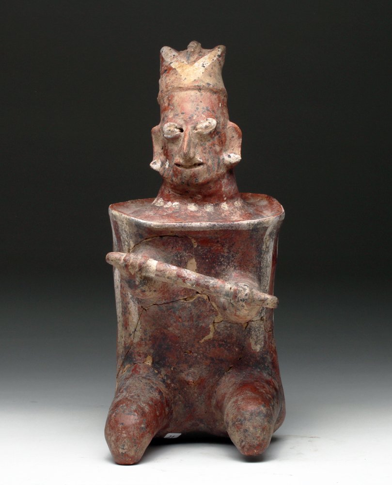 Jalisco Terracotta Seated Warrior: Pre-Columbian, West Mexico, Ca 200 BCE / 200 CE. Stoic warrior shown in seated position, he wears barrel-shaped armor decorated with white vertical stripes, crested helmet is upon his head, holding sp