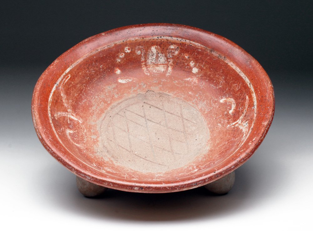 Lg. Michoacan Terracotta Grater Bowl: Pre-Columbian, West Mexico, ca. 300 BCE - 300 CE. Beautifully painted in red and cream with elegant designs. Incised cross-hatching in the center. The bowl sits on three conical legs, all of which are
