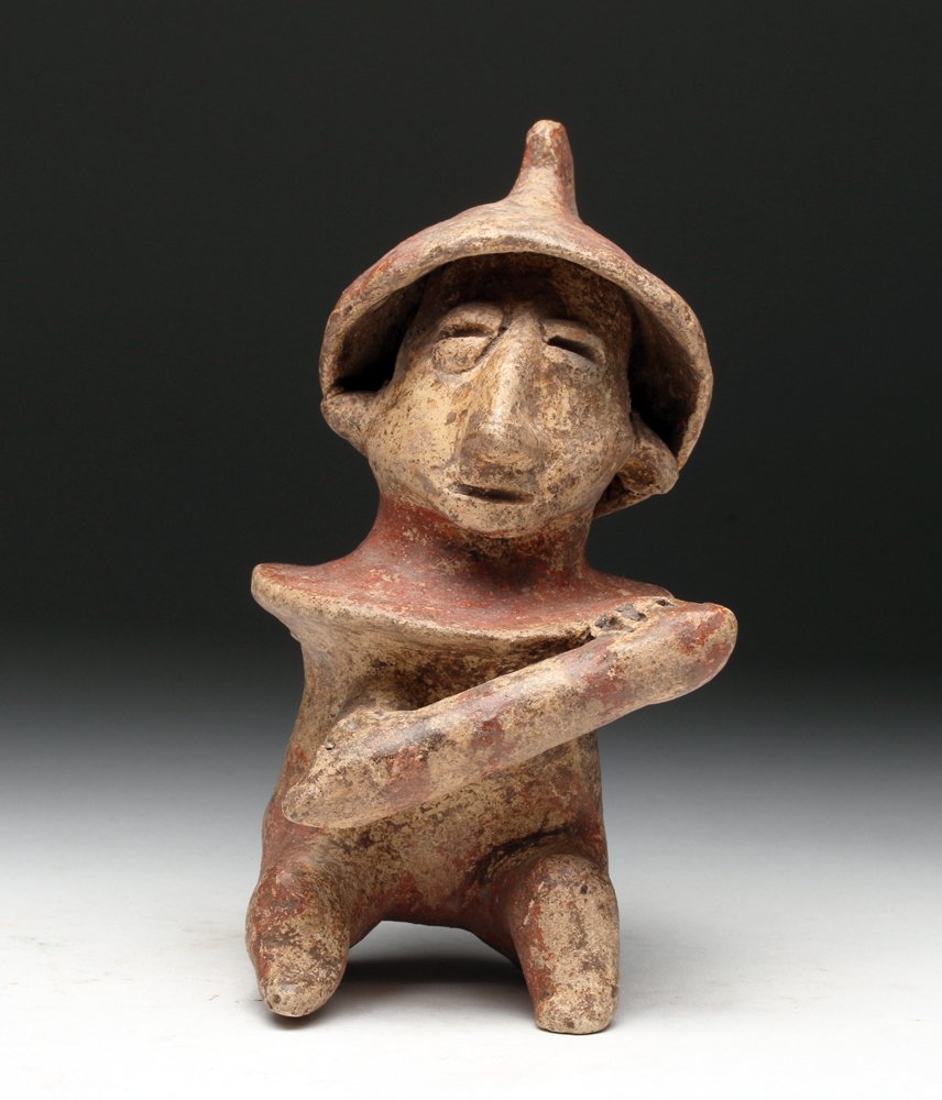 Jalisco Pottery Seated Warrior: Pre-Columbian, Western Mexico, Jalisco region, ca. 300 BCE to 300 CE. Cute solid pottery warrior. He sits in his barrel armor and crested helmet holding club in both hands, painted with added red and 