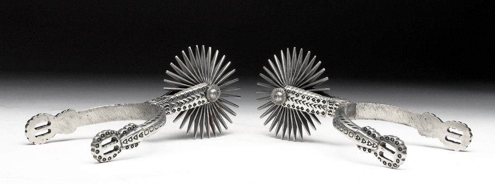 South American Silver Plated Spurs: South America, ca. early 20th century. Pair of matched goucho spurs in silver plated iron. Each wonderfully decorated and showing a bit of use. Size: 6-3/4" L. Provenance: Ex-US auction house. All ite