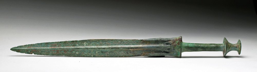 Superb Luristan Bronze Short Sword > 19-7/8"L: Northwestern Iran, Luristan, ca. late 2nd to early 1st millennium BCE. Gorgeous bronze sword with spooled pommel, rounded handle, wide blade with large blood ridge and fine herringbone pattern along l