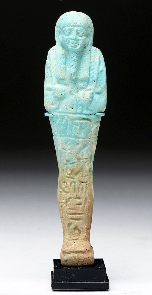 Egyptian Blue Faience Ushabti: Egypt, Late Dynastic Period, ca. 652 to 300 BCE. A faience ushabti of beautiful aqua blue hues in traditional mummiform form with hands to chest holding crook and flail, pillar down back indicates 26t