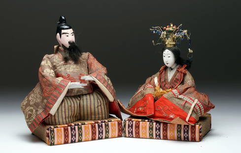 Pr Japanese Meiji Period Hina Dolls - Emperor, Empress: Japan, Edo to Meiji Period, ca. 1860 to 1900 CE. A fine pair of Japanese Emperor and Empress dolls, or kokin-bina, presented in formal court dress. Both sit upon decorated "books" made of silks and