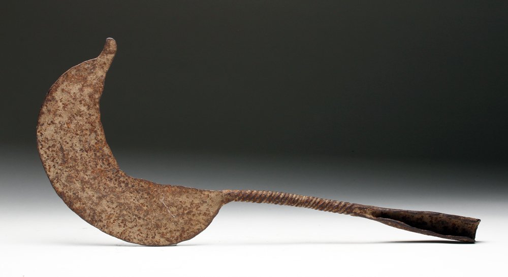 19th C. African Sickle-Shaped Iron Weapon: Africa, Cameroon, ca. late 19th to early 20th century CE. Deadly iron weapon in sickle shape with twisted shaft, open sleeve and curved blade. Size: 16-5/8"L at widest point. Provenance: Ex-Sarkisian 