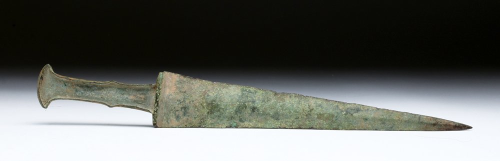 Fine Luristan Bronze Dagger / Short Sword: Luristan, Central Asia, ca. 1000 BCE. Solid bronze blade with long triangular blade with flared handle recessed to accept a bone or wooden grip. Size: 13-3/8"L (34cm). Provenance: Ex-private Scott McC