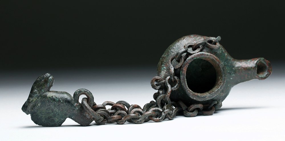 Byzantine Bronze Oil Lamp with Chain: Byzantine, modern-day Middle East / Turkey, ca. 400 to 600 CE. This bronze oil lamp could have been hung on a hook inside or outside the home. It has a handsome bronze camelid at the top of the chain 
