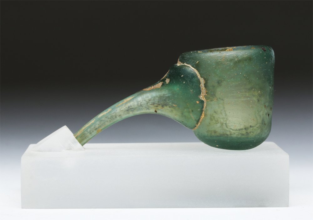 Near-Miniature Roman Glass Baby Feeder, ex-Ariadne: Rome, ca. 100 CE. This delicate ancient blue-green glass object has a small bowl and a narrow, tapered straw from one side. Glass blowing technology, developed in the Roman Empire in the 1st century C
