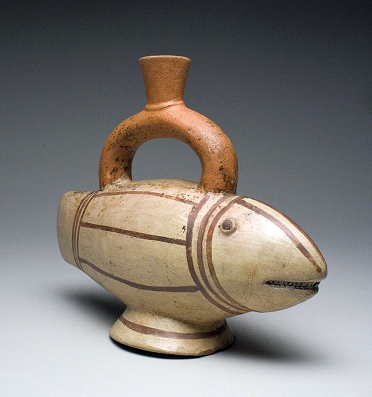 Inca Polychrome Fish Vessel: Pre-Columbian, Central Peru, ca. 1400 CE. One of the most delightful vessels we have handled from this region! Pottery stirrup vessel in the form of a toothy fish. Painted in white, orange and brown w