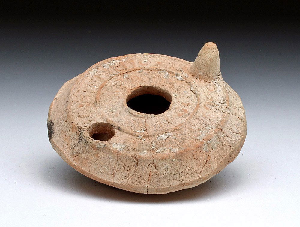 Roman Redware Oil Lamp - Hebrew Text: Rome, Imperial Period, Holy Land, ca. 4th to 5th century CE. Very rare and desirable oil lamp. Mold made with two bands of Hebrew text in concentric circles, underside with six pointed star likely sig