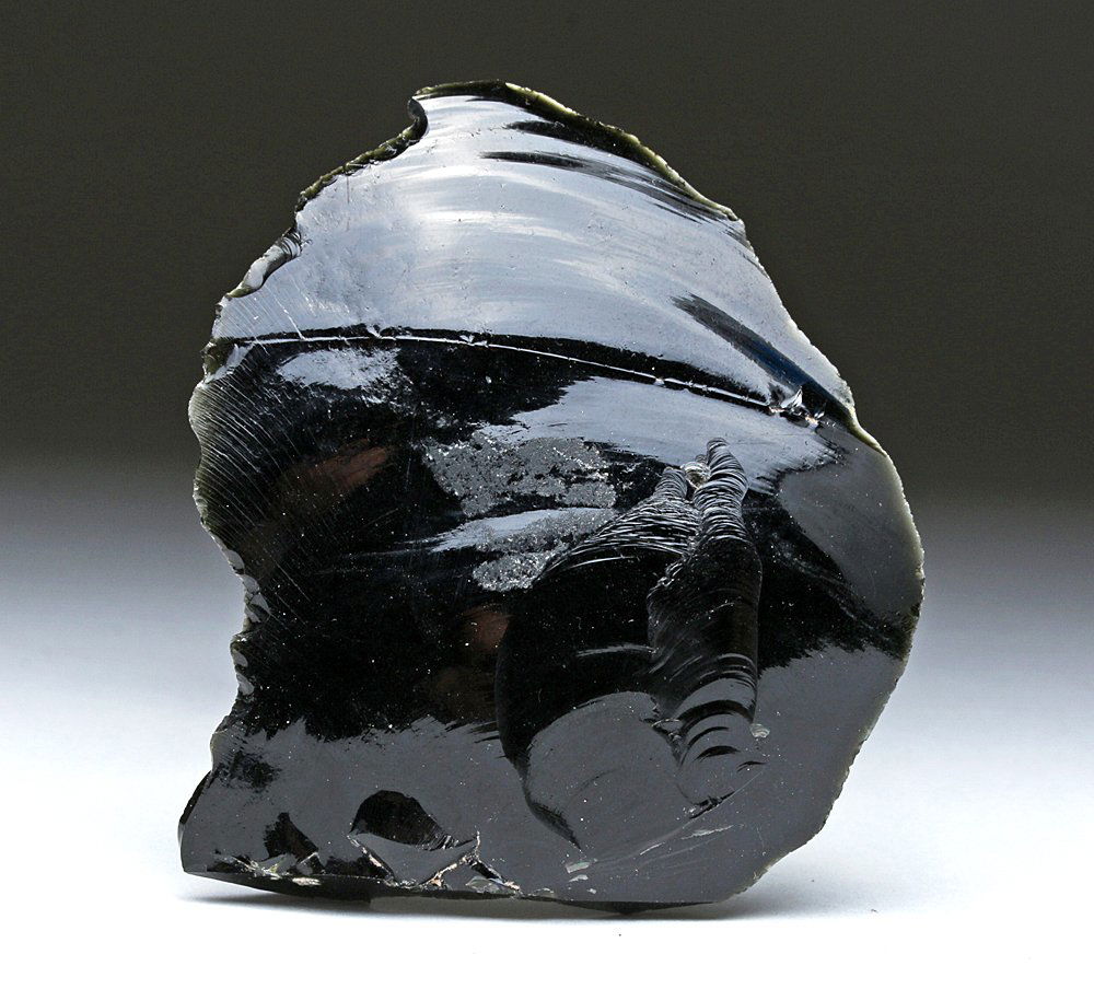 Pre-Columbian Obsidian Scraper: Pre-Columbian, Mexico, Ca 300 BCE to 300 CE. Deep black obsidian scraper nicely knapped on each side. Fits nicely into one's hand. Used to slice hide from carcasses. When held to light, the deep black