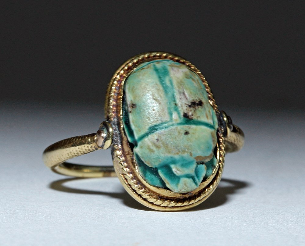 Egyptian Faience Scarab 14K Ring, ex-J. Malter: Egypt, probably New Kingdom, ca. 1550 to 1069 BCE. This is a charming blue-green scarab set into a modern 14k gold ring. On the underside of the scarab, visible on the inside of the ring, is an abstra