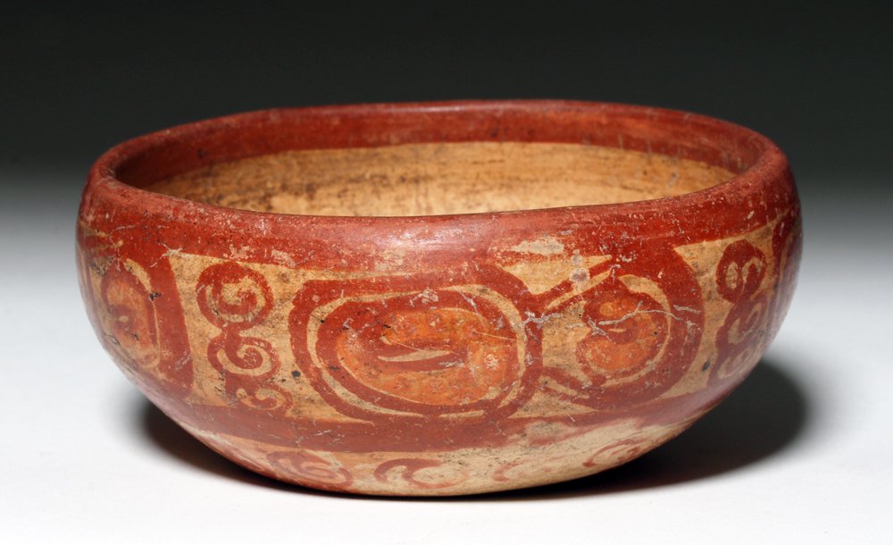 Mayan Polychrome Pottery Bowl: Pre-Columbian, Mayan, ca. 550 to 900 CE. Finely decorated Mayan bowl with rounded shoulders. Bowl is decorated with stylized pseudoglyphs in red and orange over cream. Areas of exterior, interior and 